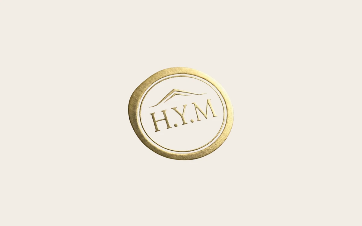 The HYM-LAW identity — the gold embossed seal from the delivered pack